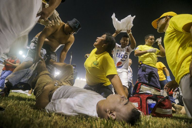 Aficionados al fútbol atienden en la cancha a los heridos por una estampida humana en el estadio Cuscatlán de San Salvador, el sábado 20 de mayo de 2023. (AP Foto/Milton Flores)