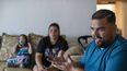 El solicitante de asilo venezolano Luis López habla con The Associated Press mientras su esposa, Oriana Marcano, y su hija Amaloha López escuchan, el viernes 12 de mayo de 2023, en El Paso, Texas. Cuando López se perdió el año pasado en la selva del Darién con su esposa, entonces embarazada de siete meses, sus dos hijos pequeños y la abuela de ella, con frecuencia se arrodillaba en el lodo para suplicar a Dios que no les abandonara. (AP Foto/Andrés Leighton)
