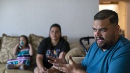 El solicitante de asilo venezolano Luis López habla con The Associated Press mientras su esposa, Oriana Marcano, y su hija Amaloha López escuchan, el viernes 12 de mayo de 2023, en El Paso, Texas. Cuando López se perdió el año pasado en la selva del Darién con su esposa, entonces embarazada de siete meses, sus dos hijos pequeños y la abuela de ella, con frecuencia se arrodillaba en el lodo para suplicar a Dios que no les abandonara. (AP Foto/Andrés Leighton)