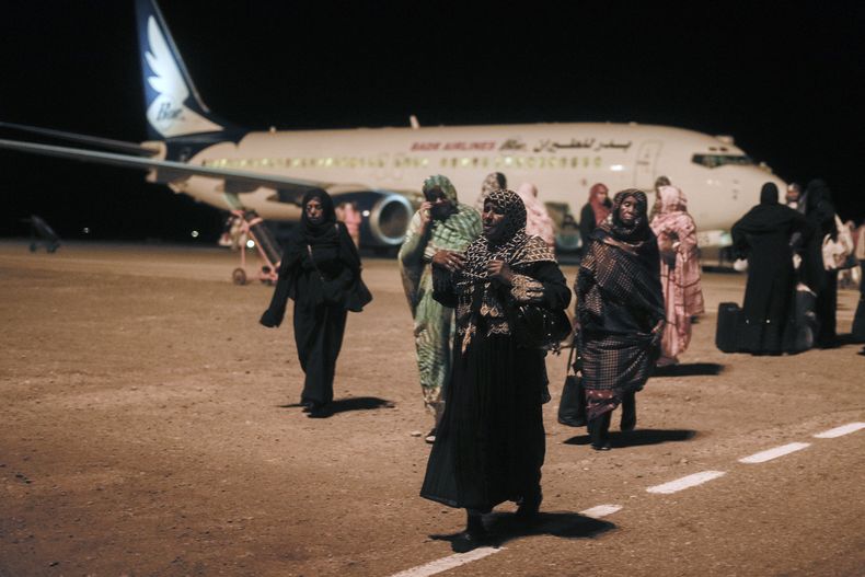Un grupo de sudaneses que estaban varados en Yida, Arabia Saudí, llegan al aeropuerto de Port Sudan el 11 de mayo de 2023. (Foto AP /Amr Nabil)