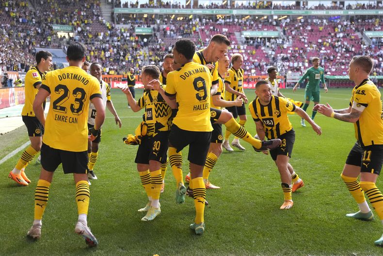 Los jugadores del Borussia Dortmund celebran su victoria ante Augsburgo en la Bundesliga, el domingo 21 de mayo de 2023. (AP Foto/Matthias Schrader)