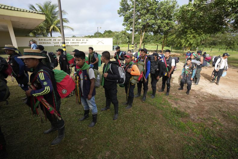 Indígenas hacen fila para abordar un helicóptero en una base militar en Calamar, Colombia, el martes 23 de mayo de 2023, para ayudar en la búsqueda de cuatro niños desaparecidos después de un accidente aéreo. (AP Foto/Fernando Vergara)